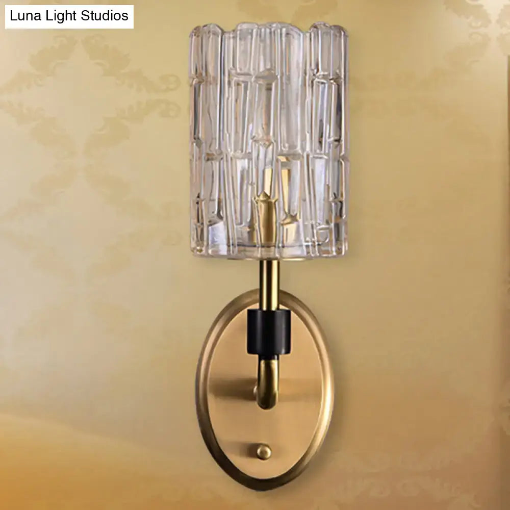 Contemporary brass bedside wall sconce with clear crystal shade bedroom