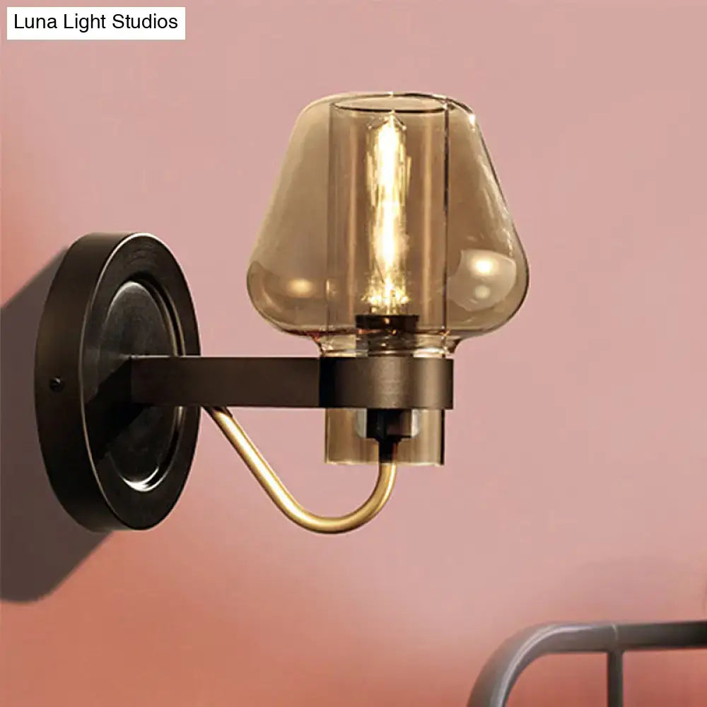 Modern black and brass wall sconce with amber glass bedroom light