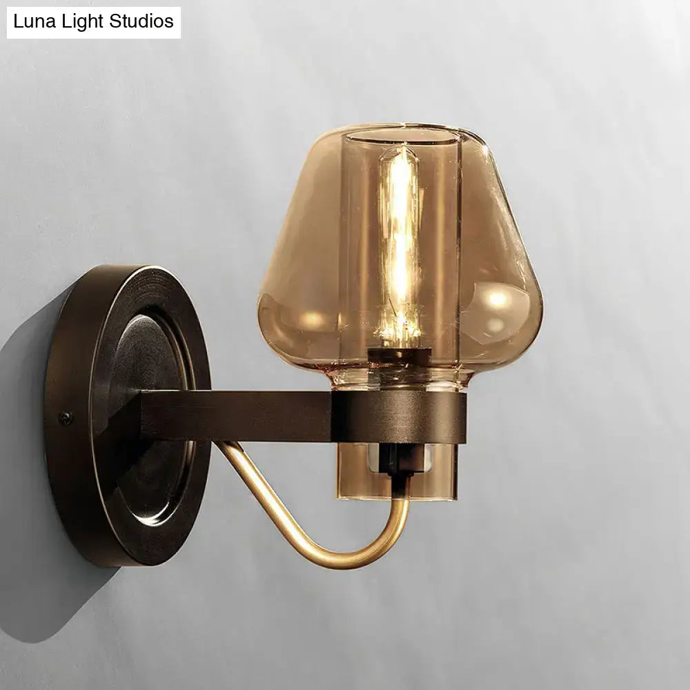 Modern black and brass wall sconce with amber glass bedroom light