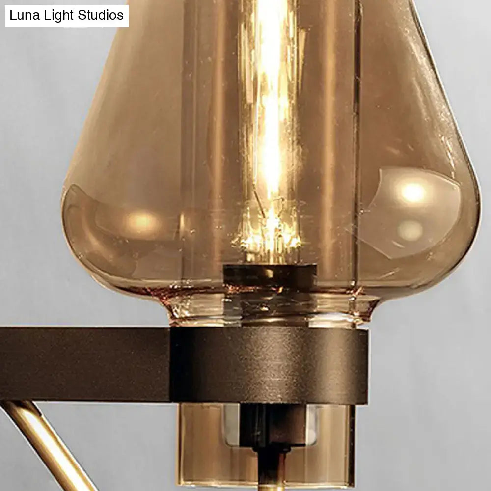 Modern black and brass wall sconce with amber glass bedroom light