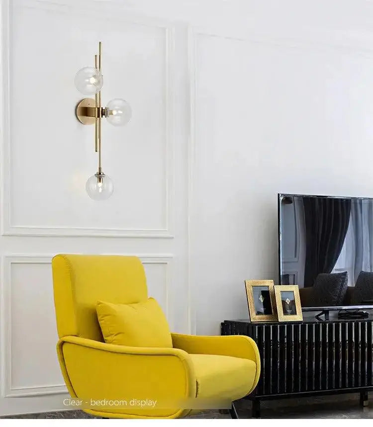 Modern gold wall sconce with textured glass globes for bedroom