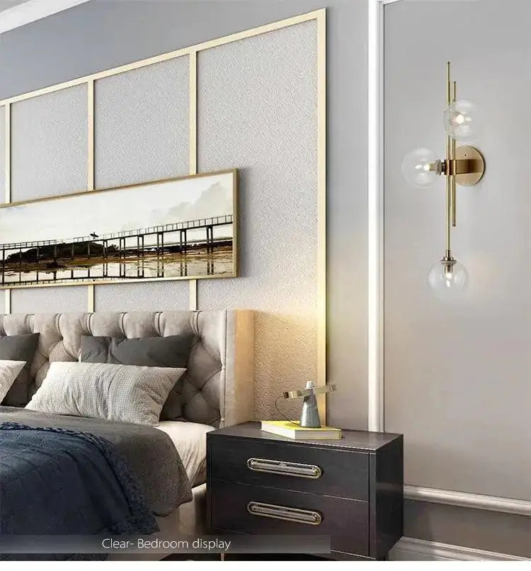 Modern gold wall sconce with textured glass globes for bedroom