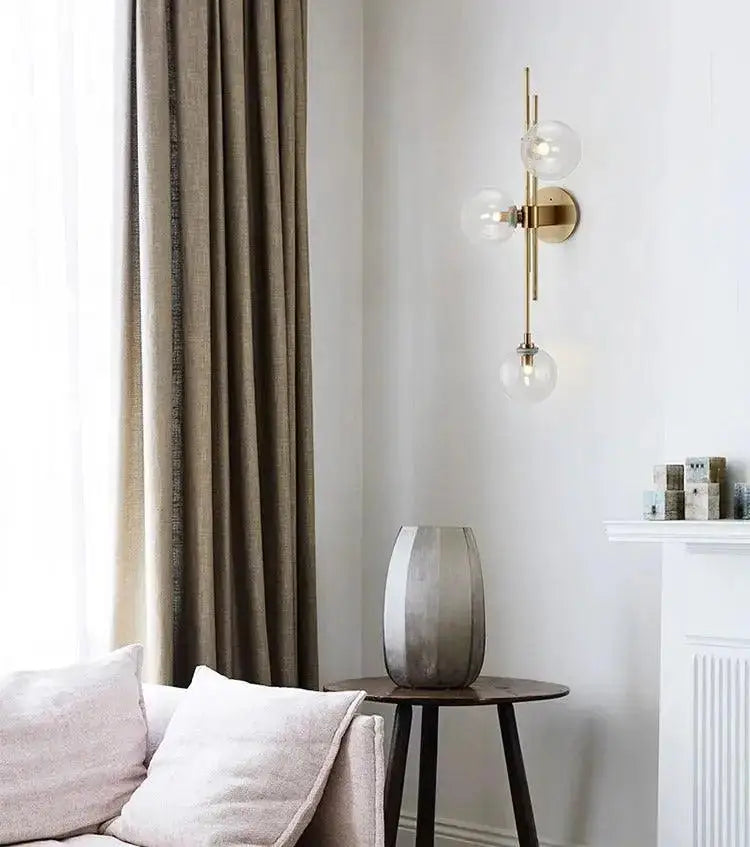 Modern gold wall sconce with textured glass globes for bedroom