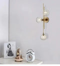 Modern gold wall sconce with textured glass globes for bedroom