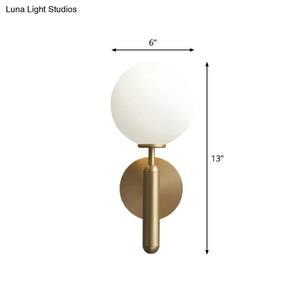 Minimalist brass wall sconce with cream glass shade for living room
