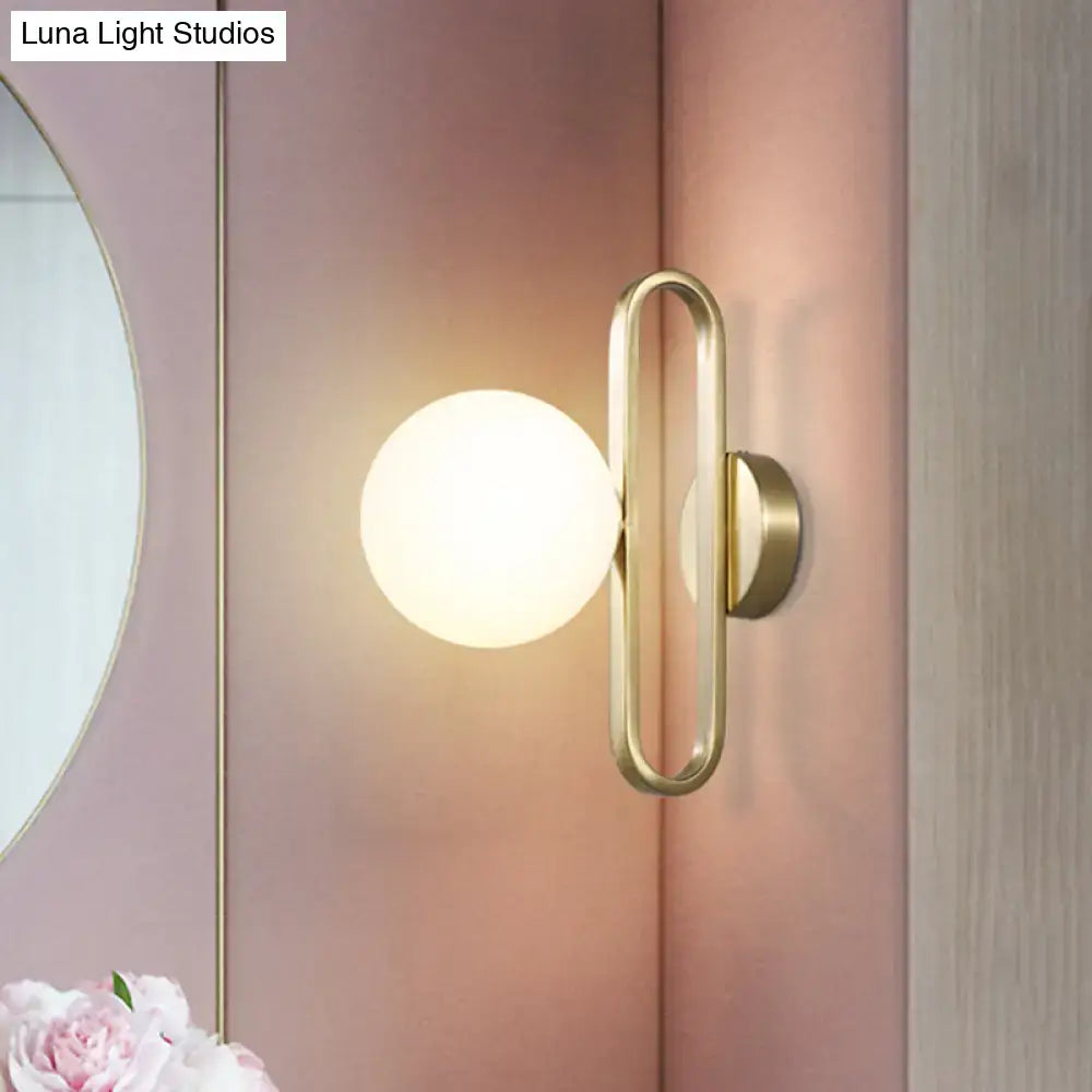 Minimalist gold oval arm wall light with cream matte glass bedroom sconce