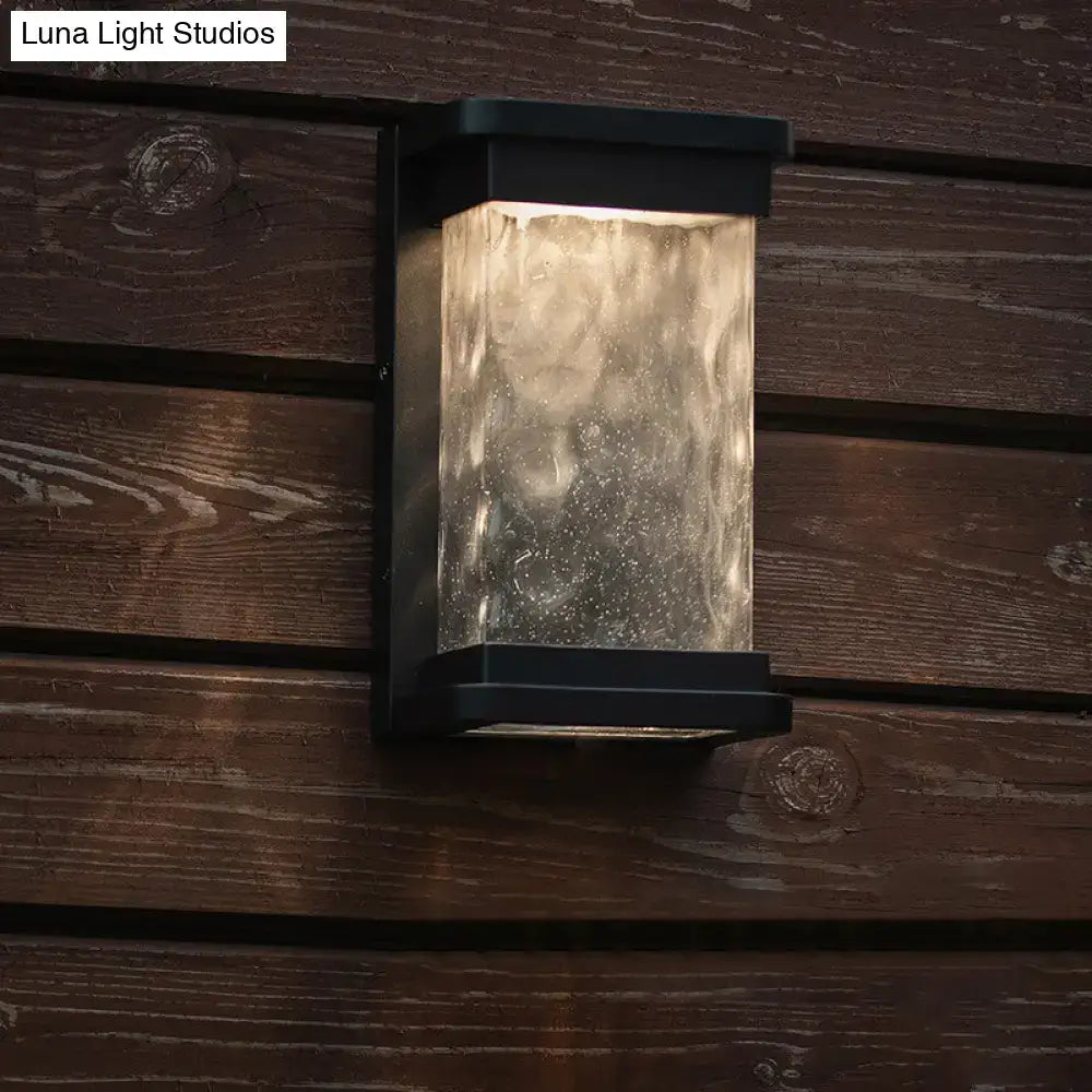 Modern black led outdoor wall sconce with rippled glass cylinder