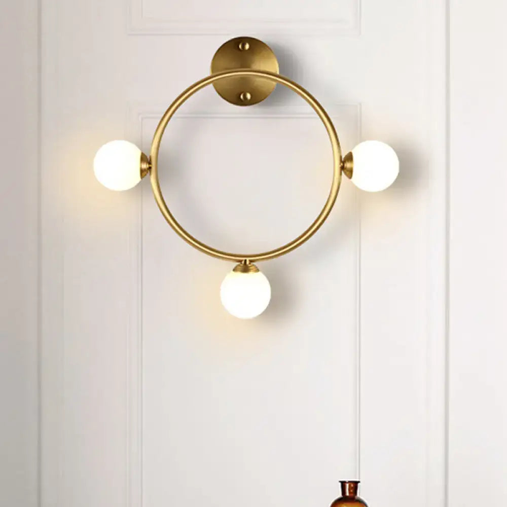 Modern brass circular wall light fixture with glass shades bedroom