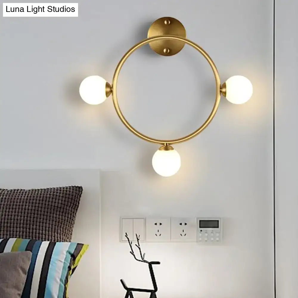 Modern brass circular wall light fixture with glass shades bedroom
