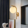 Modern brass globe bedside lamp with frosted glass for bedroom