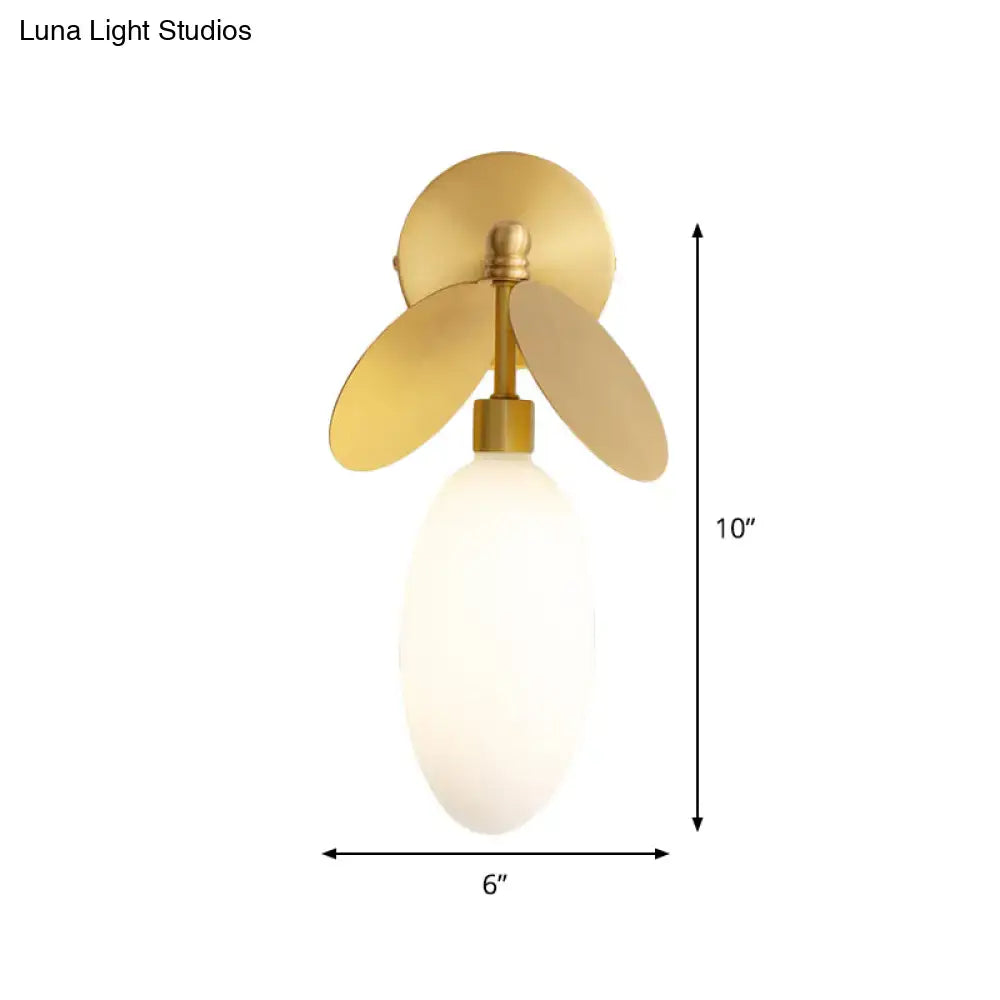 Modern brass leaf wall lamp with cream glass bedroom sconce