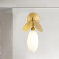 Modern brass leaf wall lamp with cream glass bedroom sconce