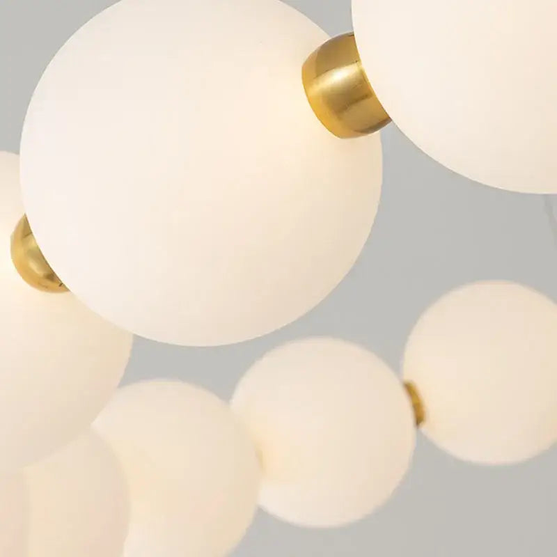 Modern brass led pendant light with frosted spheres for living room