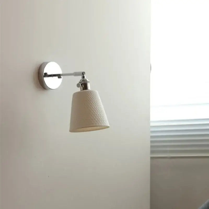 Modern chrome wall light with perforated fabric shade for bedroom