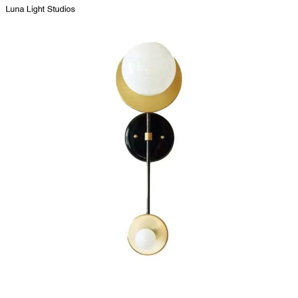 Modern gold and black wall sconce with opal glass shade bedroom light