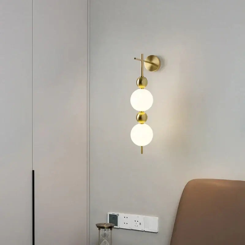 Modern gold led wall sconce with frosted glass spheres for bedroom