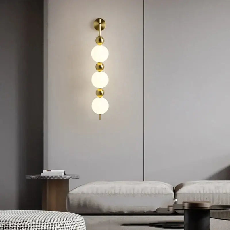 Modern gold led wall sconce with frosted glass spheres for bedroom