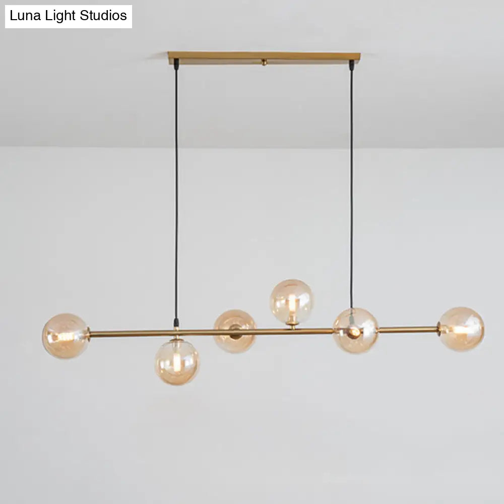 Modern gold metal island pendant with blue glass spheres dining room