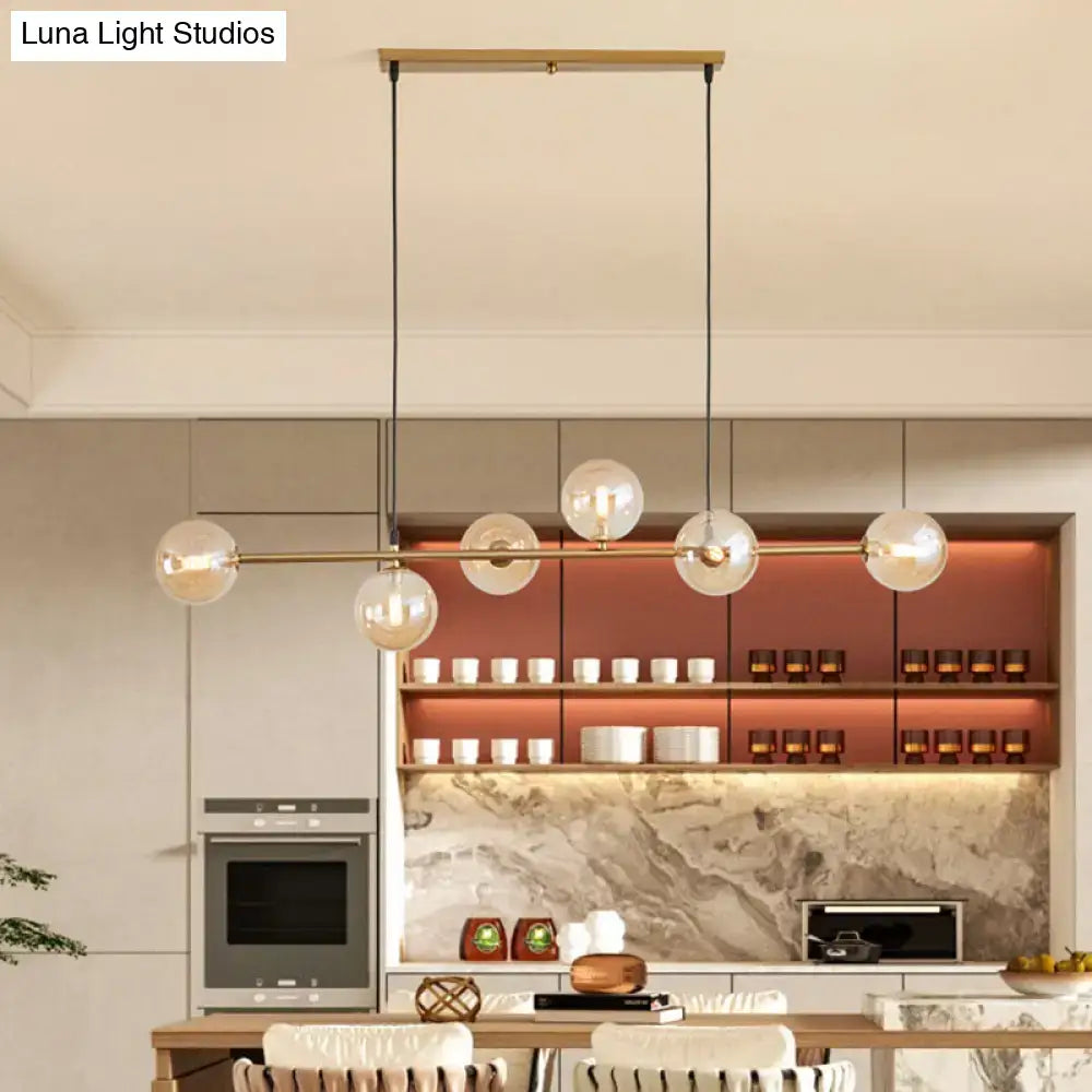 Modern gold metal island pendant with blue glass spheres dining room