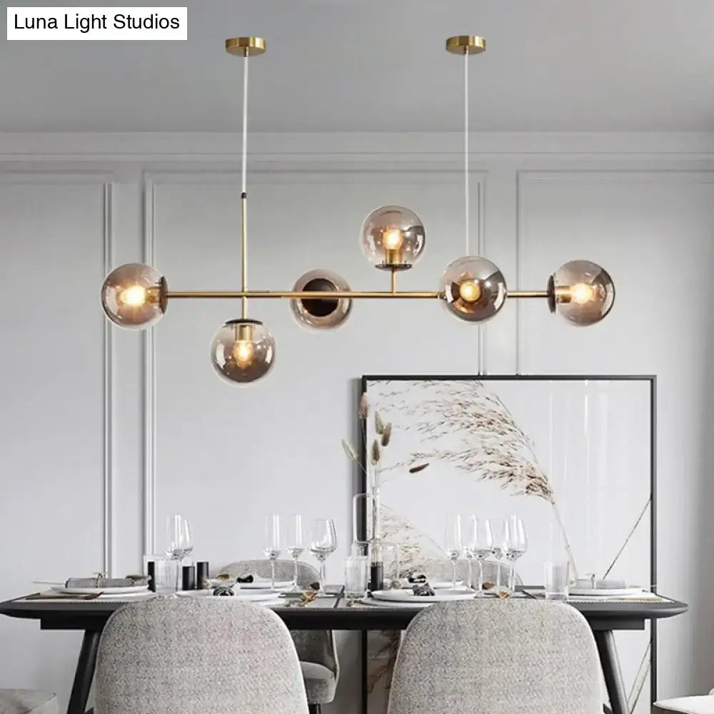 Modern gold metal island pendant with blue glass spheres dining room