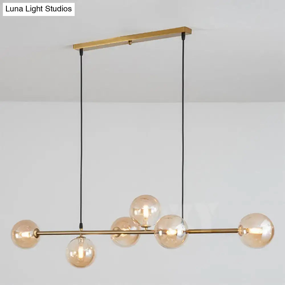 Modern gold metal island pendant with blue glass spheres dining room