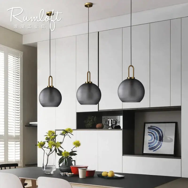 Modern gray glass ball pendant lights – dining room brass accents