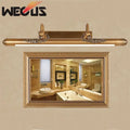 Ornate brass bathroom mirror lamp with decorative scrollwork