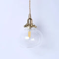 Teal glass ball pendant light with brass hardware for bedroom